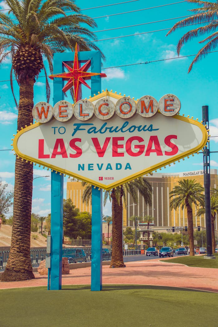 Famous Welcome to Fabulous Las Vegas sign with palm trees under a blue sky.